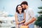 Young couple with shopping bags walking by the harbor of a touristic sea resort with boats on background