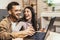 Young couple shopping together, customers paying by credit card online, sitting in cozy living room at home