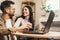 Young couple shopping together, customers paying by credit card online, sitting in cozy living room at home