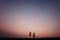 Young couple silhouette jumping outdoors at sunset dramatic