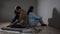 Young couple sits in dark room after quarrel over renovations
