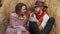 A young couple sits on hay in the farm. Happy smiling cowboy and woman spend time together