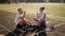 Young couple sits on a treadmill at the stadium and drinks water after a workout