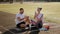 Young couple sits on a treadmill at the stadium and drinks water after a workout