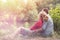 Young couple sitting amidst plants at lakeshore