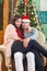 Young Couple Sitting in Armchair in Home in Festive New Year\'s