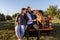 Young couple sitting on the back of a pickup truck with their trustful guardian a canine American bully