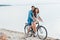 young couple sitting on bicycle on beach