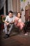 Young Couple Sitting on Cage at Messy Room