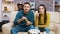 Young couple sitting on couch eating fried chicken