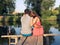 Young couple sitting embracing on the bridge by the river