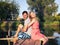 Young couple sitting embracing on the bridge by the river