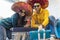 Young couple sitting on the floor at home takes a selfie wearing colorful sombrero