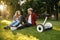 Young couple sitting on the grass near gyro board
