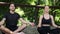 Young couple sitting in lotus yoga pose with eyes closed