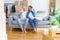 Young couple sitting on the sofa arround cardboard boxes moving to a new house doing stop sing with palm of the hand