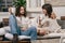 Young couple sitting on a sofa in their home relaxed talking and having a drink