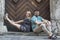 Young couple sitting on the stone threshold of the old house.