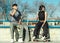 Young couple of skate boarders drinking water while having a rest in the skate park