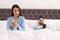 Young couple with smartphones in bed