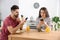 Young couple with smartphones having breakfast