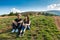 Young couple smiling, enjoying mountains lanscape, sitting on hill.