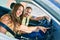 Young couple smiling happy driving car and using gps navigator smartphone