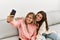 Young couple smiling happy making selfie by the smartphone at home