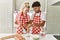 Young couple smiling happy mixing ingredients to make dough for homemade bread at kitchen