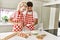 Young couple smiling happy mixing ingredients to make dough for homemade bread at kitchen