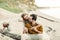 A young couple is smiling and hugging on the beach. Rustic wedding ceremony outdoors. Bride and groom look at each other