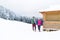 Young Couple Snowy Village Wooden Country House Man And Woman Winter Snow Resort Cottage