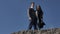 Young couple stand on a hill, in the background a blue sky, sunny spring day