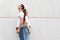 Young couple standing back to back against white urban wall