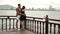 Young couple standing at deck of drifting vintage boat, talking and hugging