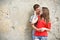 Young couple is standing grunge wall