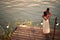 Young couple standing hugged on wooden platform by the sea, dancing slowly