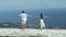 Young Couple Standing On Rocky Cliff