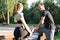 Young couple stretching their legs together while working out at park outdoors