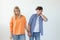 Young couple of students disgruntled boyfriend and tired young girlfriend posing on a white background holding hands