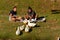 A young couple in summer clothes are sitting on picnic blanket on a sunny afternoon. They eat snacks and feed ducks