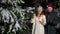 Young couple take sparklers and make congratulatory speech in winter snowy forest outdoor