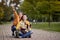 Young couple taking selfie with their dog in a lap, sitting on a path in park