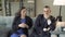 Young couple talking to a woman specialist or consultant sitting on a sofa in a modern office