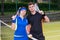 Young couple of tennis players holding a racket and a ball on t