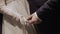 A young couple on their wedding day holds hands beautifully. The camera rotates with movement on them