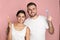 Young couple with toothbrushes on color background.