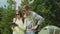 A young couple of tourists enjoy a tablet in the camping. Stand near the tent. Technology on vacation