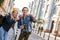 Young couple of travel bloggers are trying to take a photo in unfamiliar city