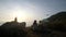 Young couple travelers flying drone at a mountain sea cliff.